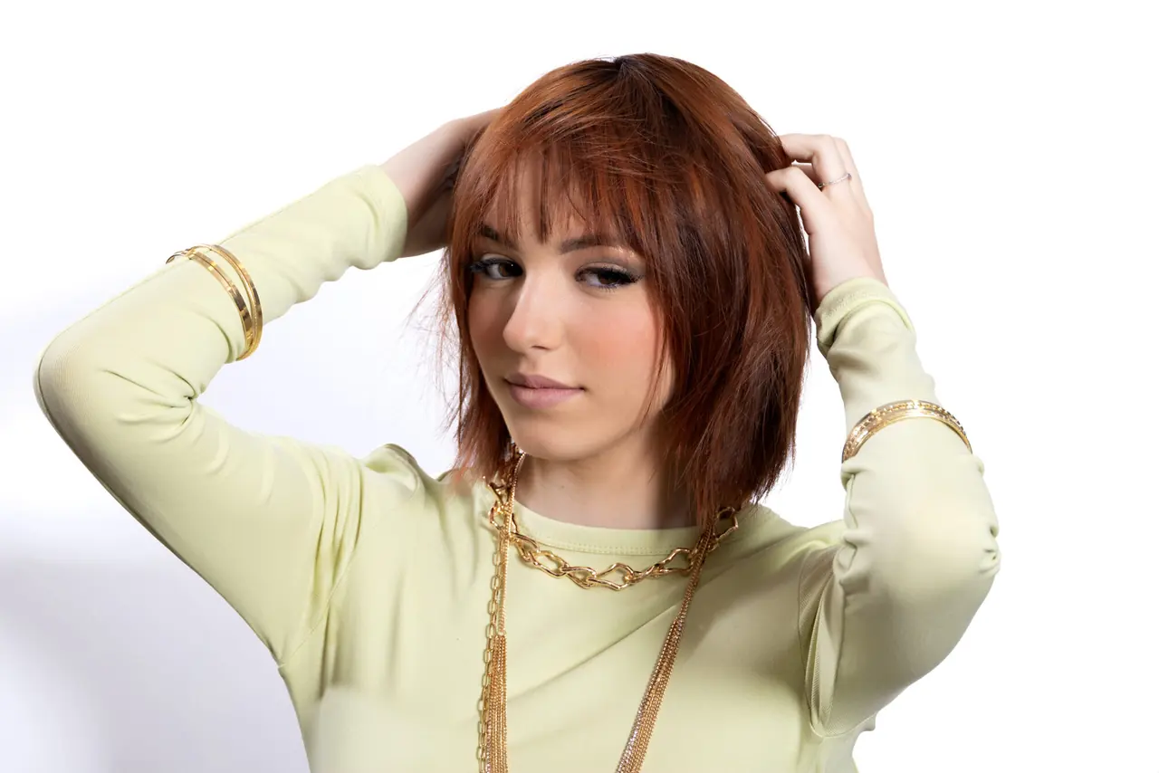 Modella con caschetto rosso e mano nei capelli, collezione Luxury Play