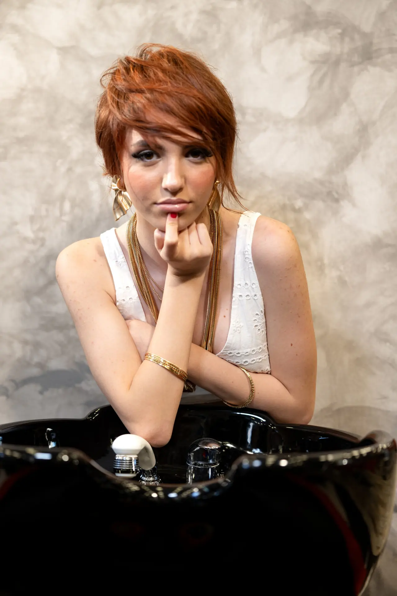 Modella con taglio corto rosso al lavatesta, terza posa, collezione Luxury Play